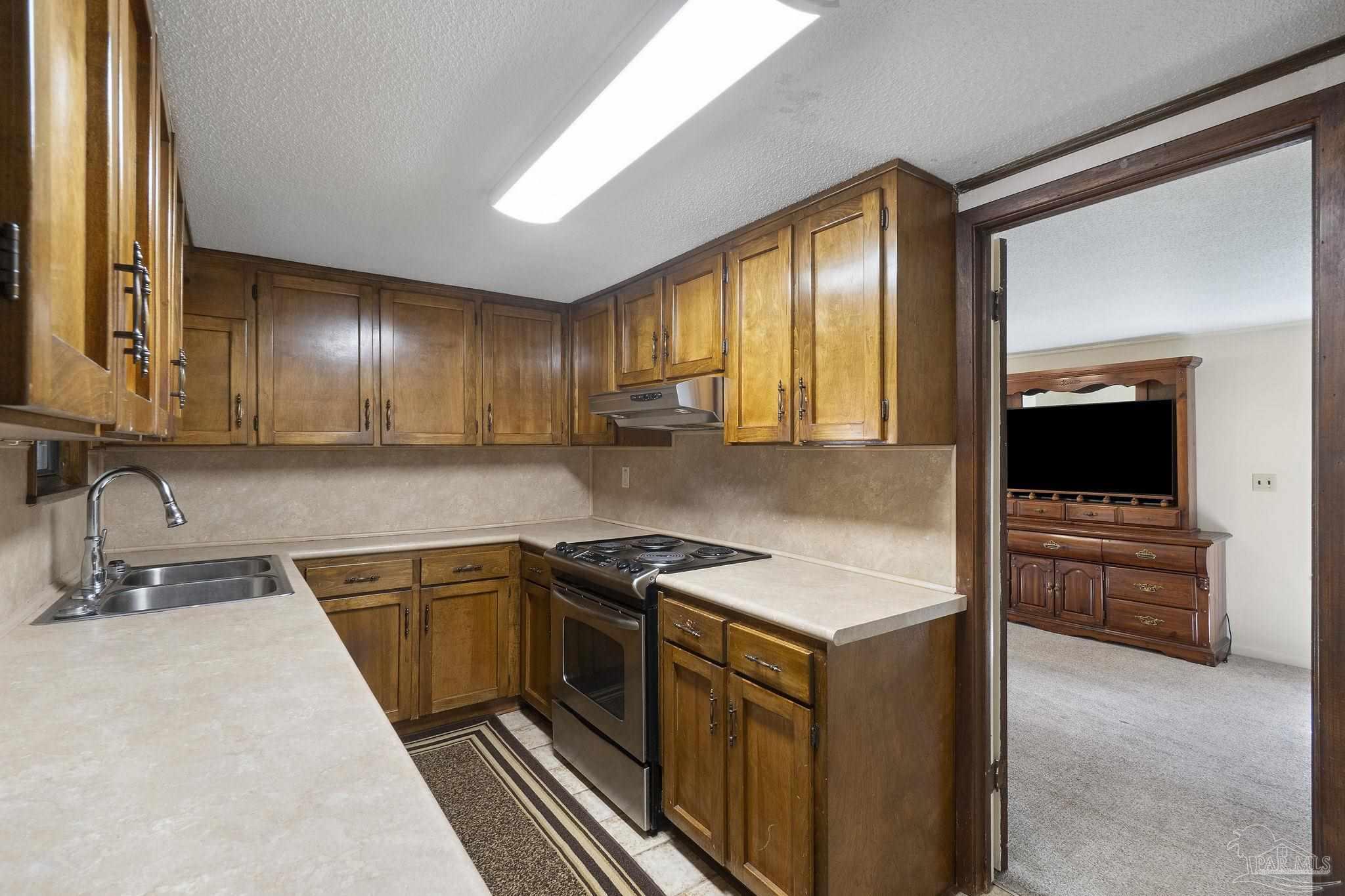 4285 7th Avenue Pace, FL 32571 - Photo 15 of 59 a kitchen that has a sink and a stove in it