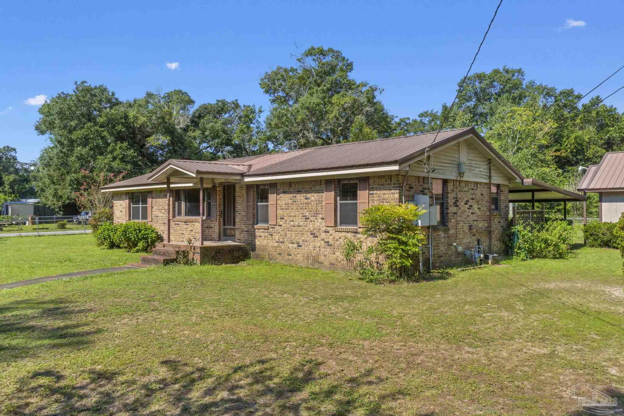 4285 7th Avenue Pace, FL 32571 - Photo 2 of 59 a front view of a house with garden