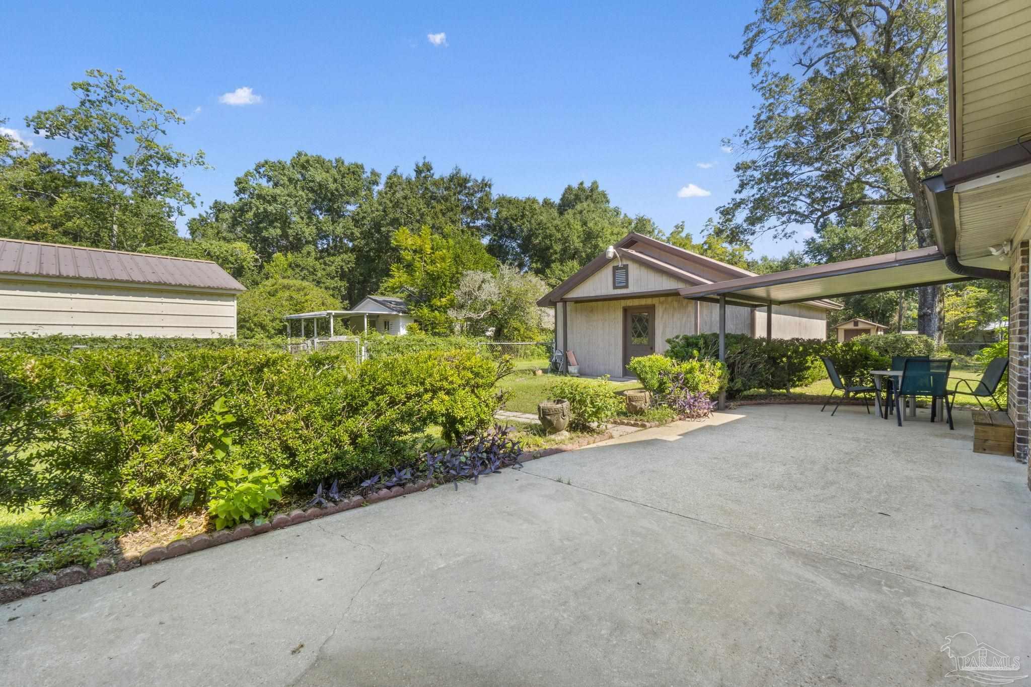4285 7th Avenue Pace, FL 32571 - Photo 32 of 59 a front view of a house with a yard and potted plants