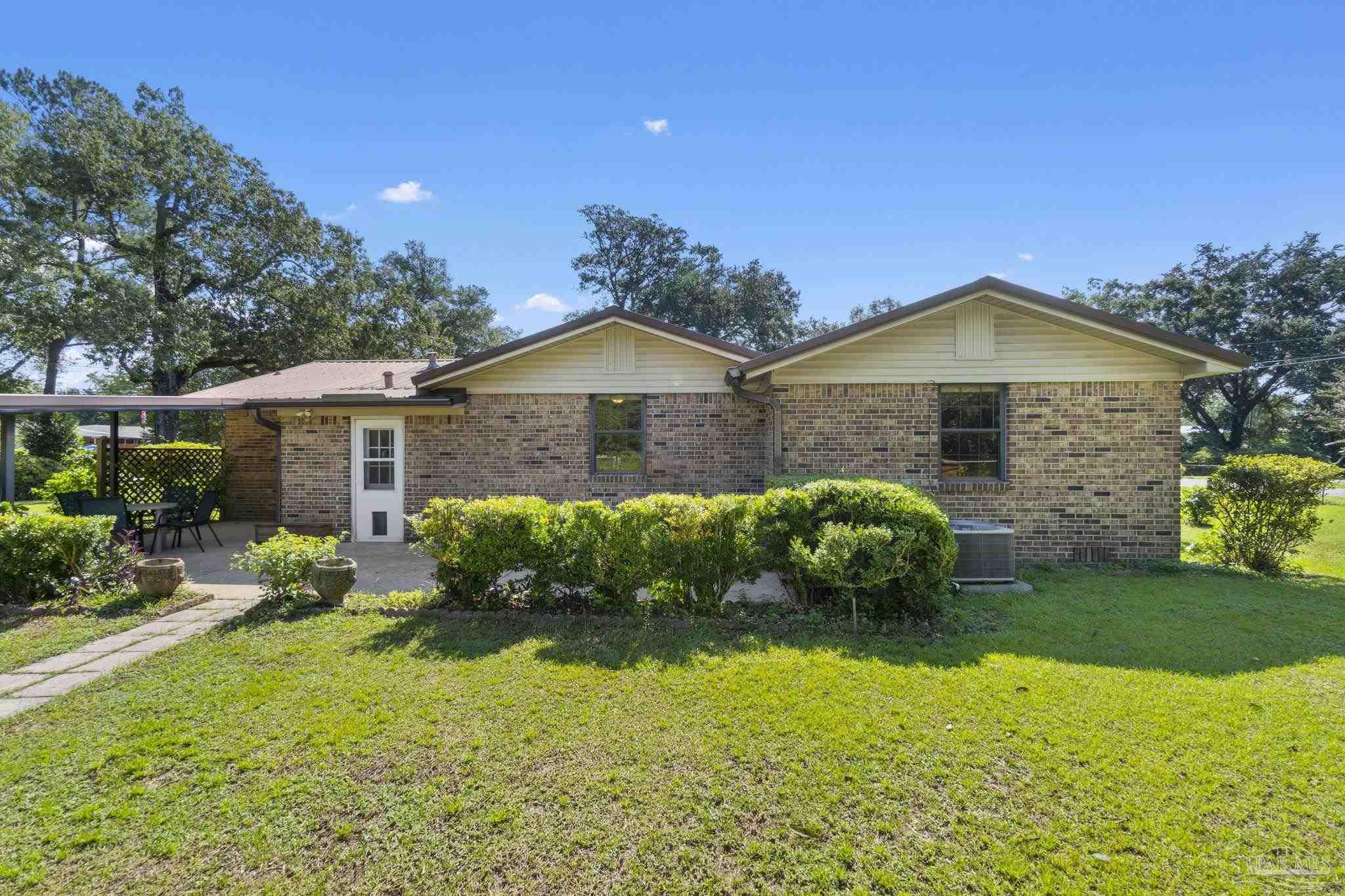 4285 7th Avenue Pace, FL 32571 - Photo 38 of 59 a front view of a house with garden