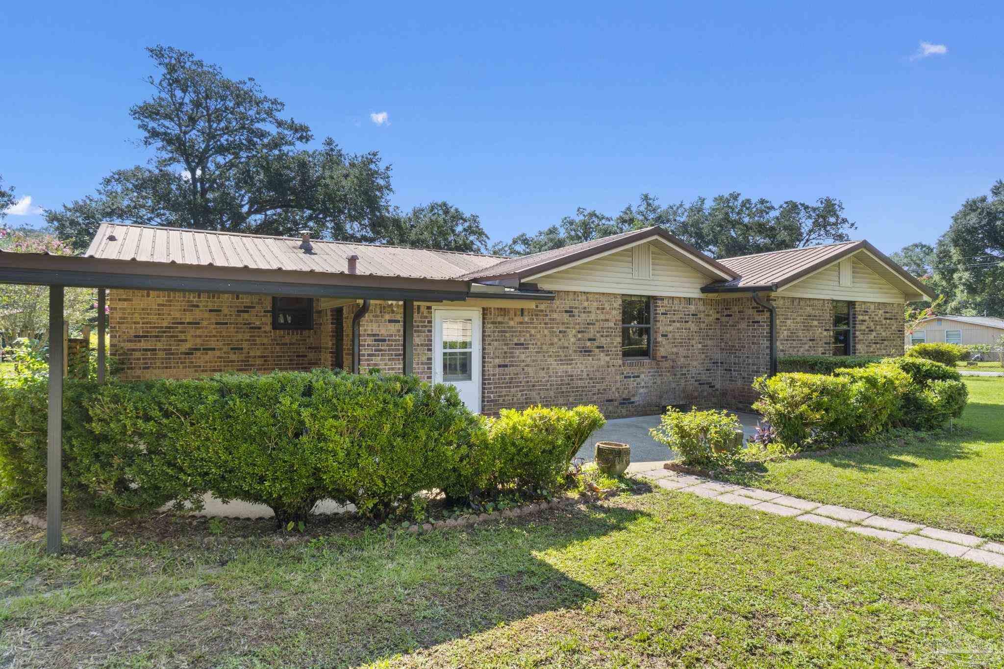 4285 7th Avenue Pace, FL 32571 - Photo 39 of 59 a front view of a house with garden