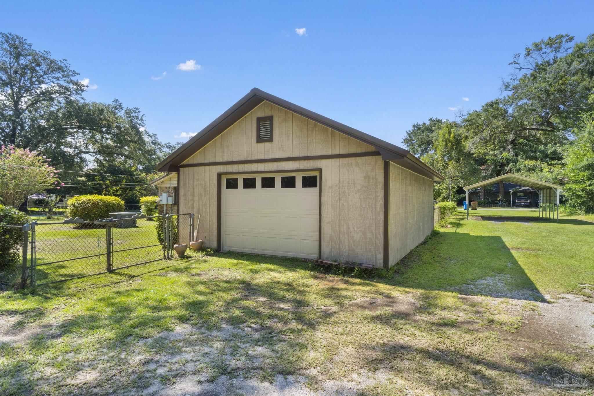 4285 7th Avenue Pace, FL 32571 - Photo 40 of 59 a front view of a house with a yard and garage