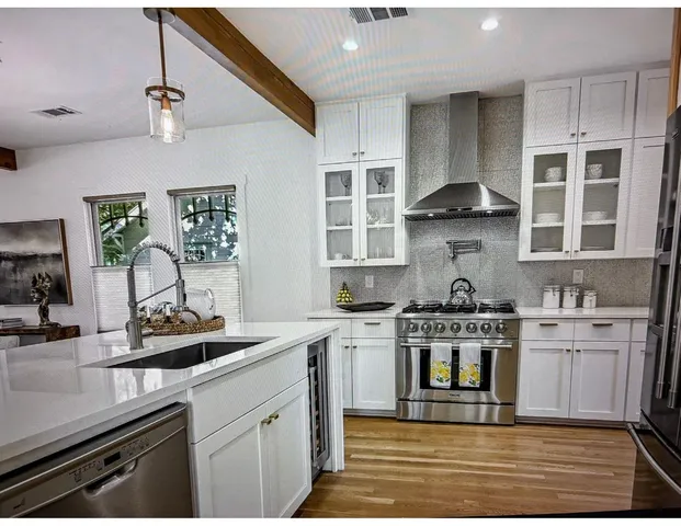 a kitchen with stainless steel appliances granite countertop a stove and a sink