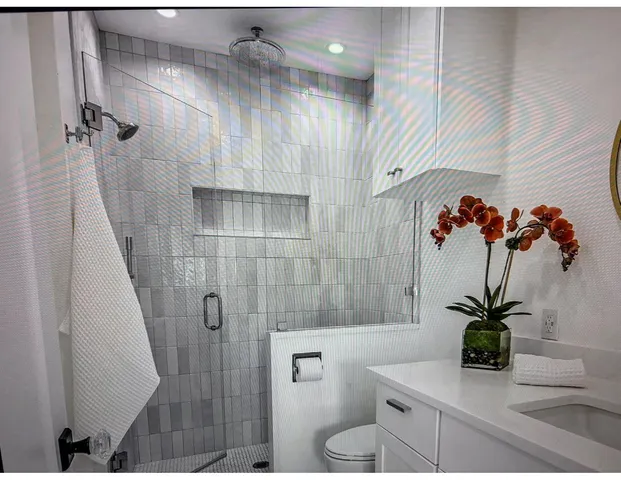 a bathroom with a shower a toilet and a sink