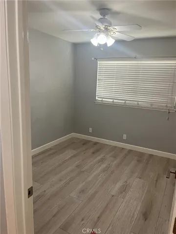 a view of a room with wooden floor and ceiling fan