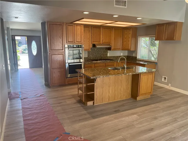 a kitchen with stainless steel appliances granite countertop a sink a stove and a refrigerator