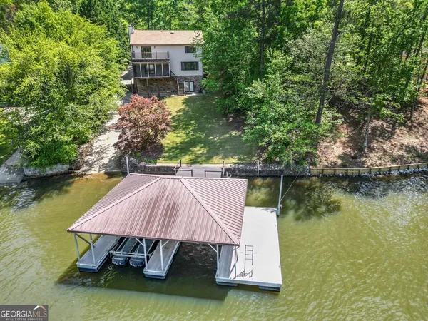 an aerial view of a house with a garden and lake view