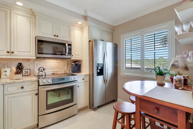 a kitchen with a sink white cabinets and stainless steel appliances