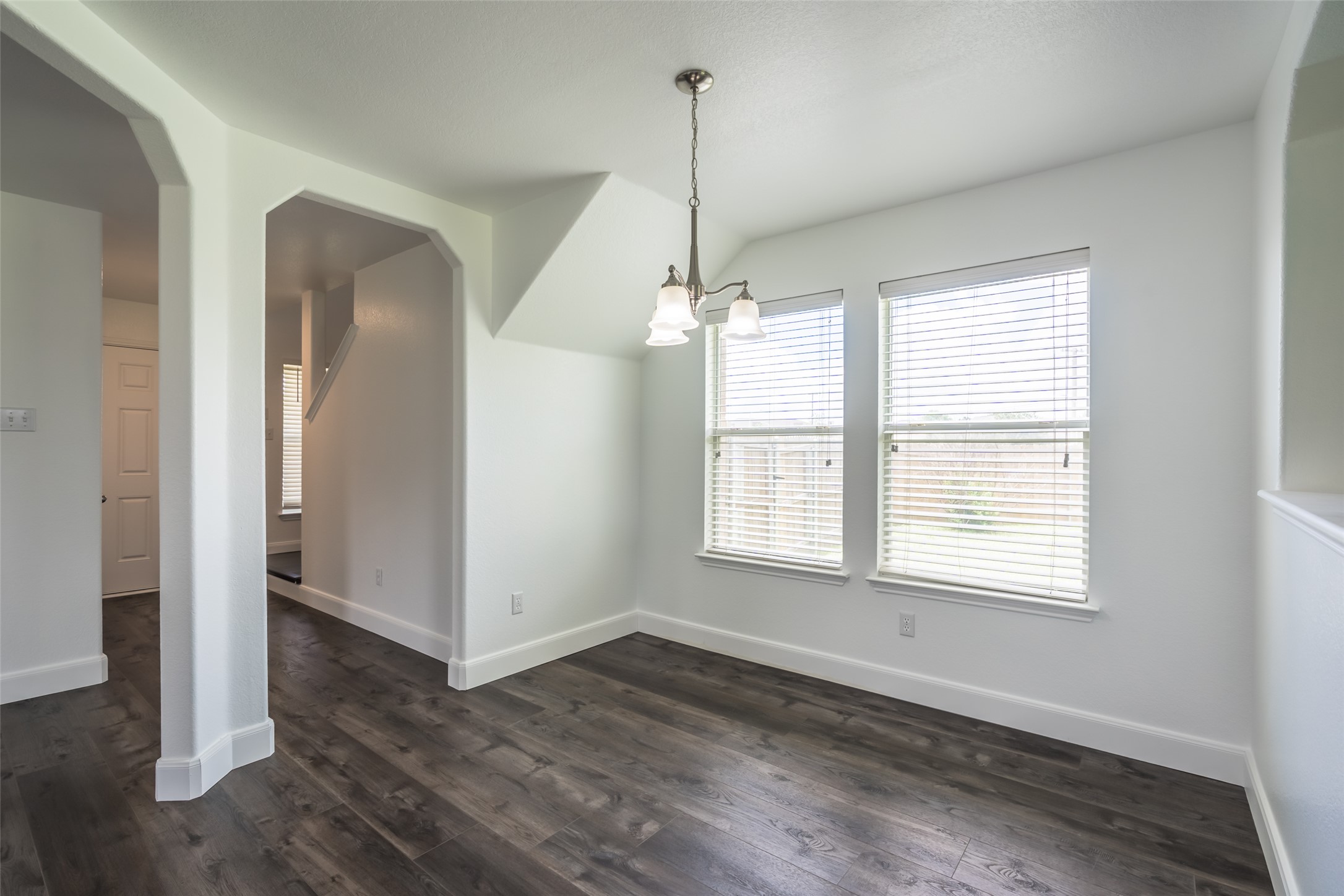 1013 Ranchero Road Leander, TX 78641 - Photo 6 of 30 Gleaming wood-look floors anchor a versatile dining space framed by wide arched doorways.