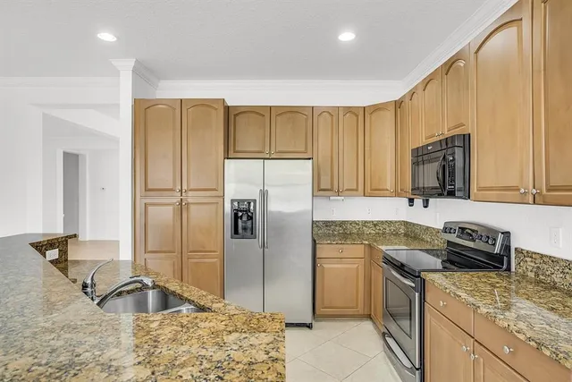 a kitchen with granite countertop a refrigerator and a sink