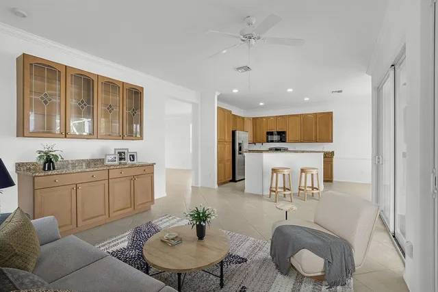 a living room with furniture kitchen view and a wooden floor