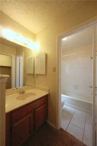 a white toilet and tub sitting next to a bathroom sink