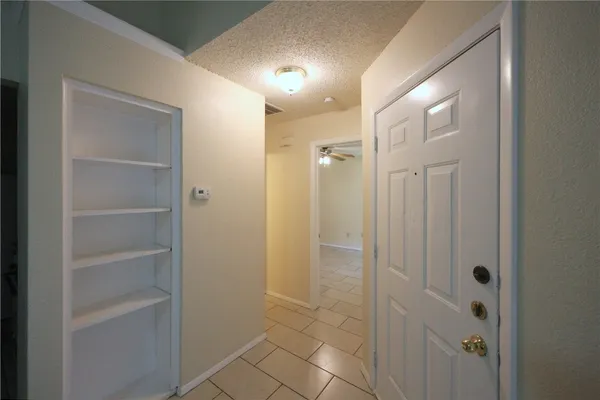 an empty room with closet and a ceiling fan