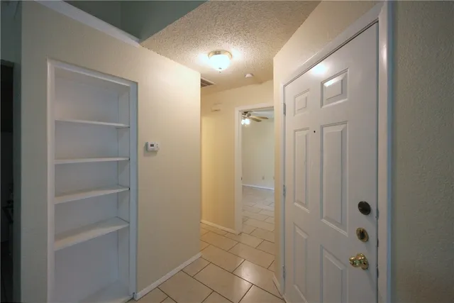 an empty room with closet and a ceiling fan