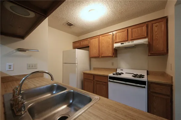 a kitchen with stainless steel appliances granite countertop a sink stove and cabinets