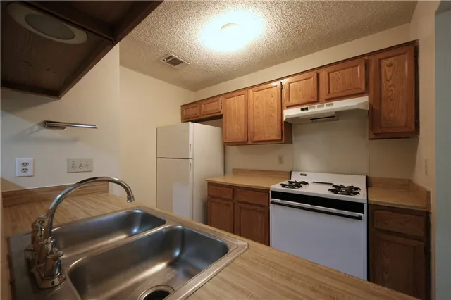 a kitchen with stainless steel appliances granite countertop a sink stove and cabinets
