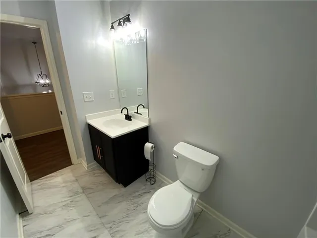 an empty room with wooden floor and fan