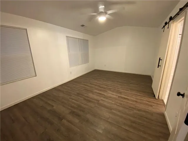 an empty room with wooden floor and white walls