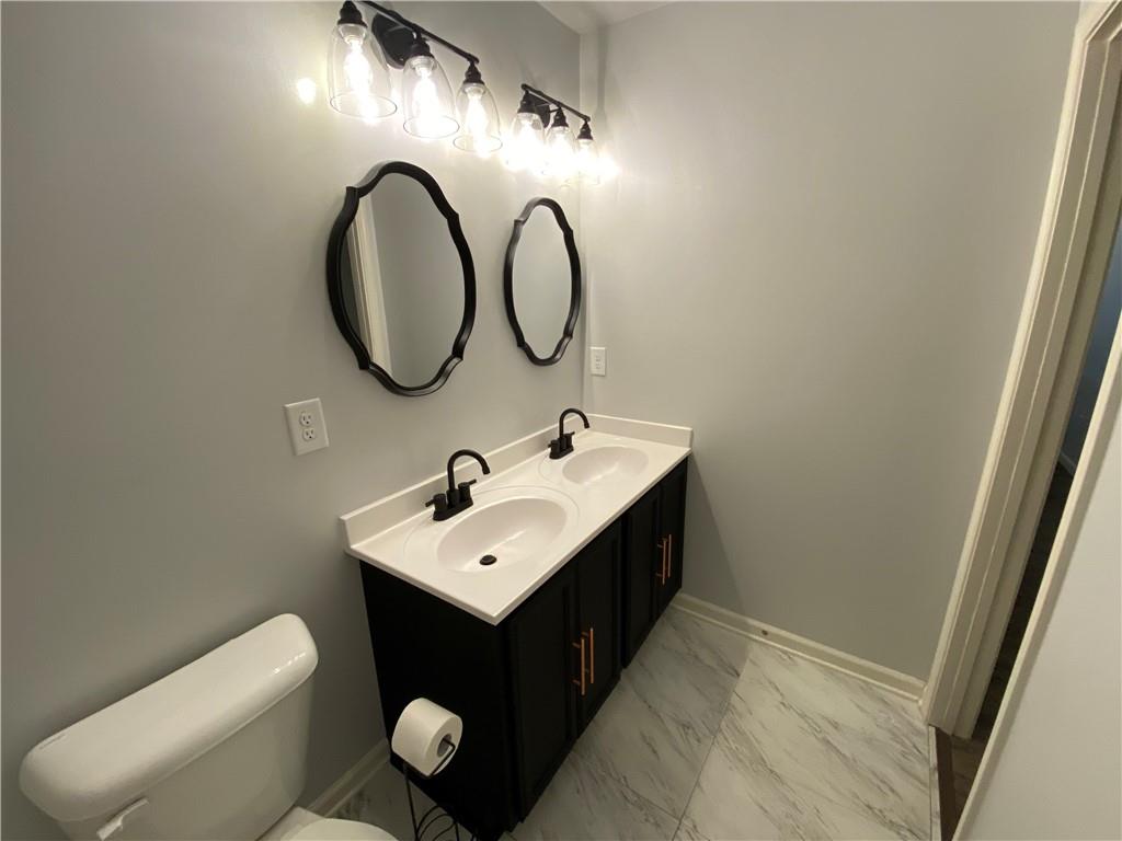 764 Dove Tree Lane Social Circle, GA 30025 - Photo 32 of 48 a bathroom with a toilet sink vanity and mirror