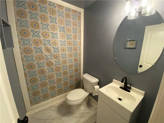 a bathroom with a sink a toilet and shower curtain