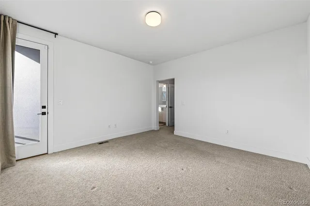 an empty room with closet and entryway