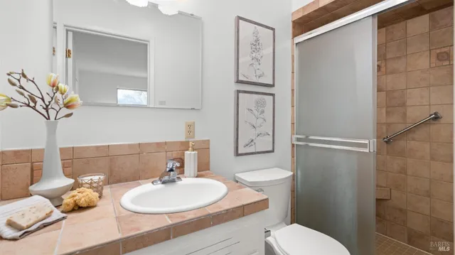 a bathroom with a sink a toilet and shower