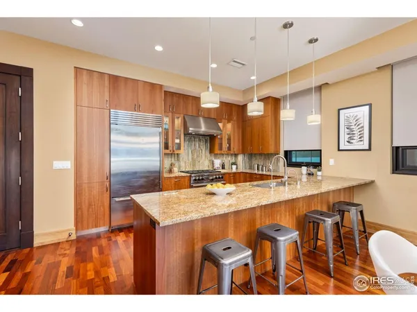 a kitchen with stainless steel appliances granite countertop a sink refrigerator and cabinets