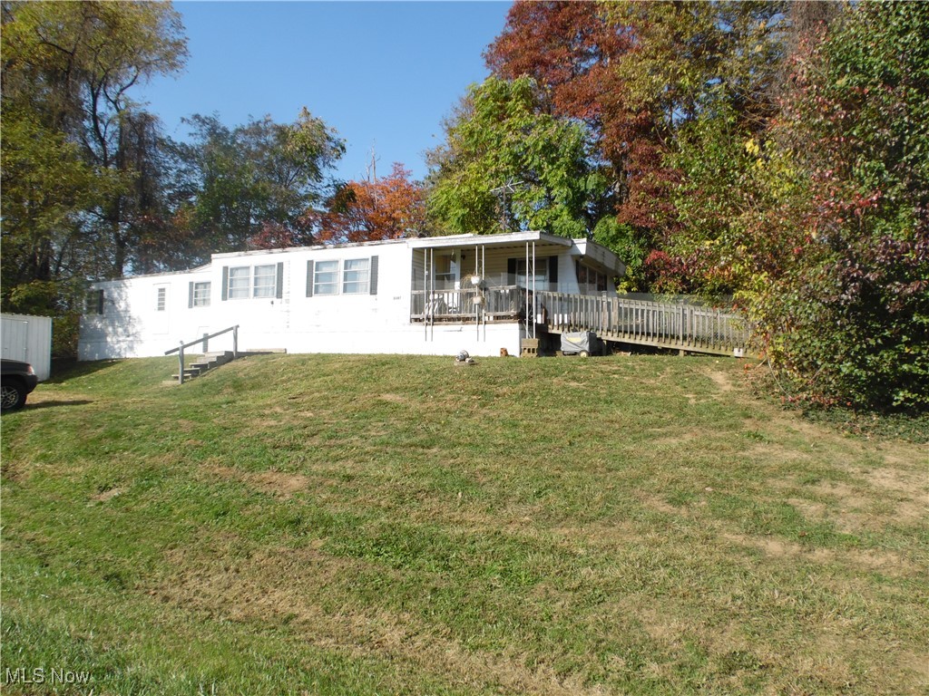 Rear view of property with a lawn and a wooden deck