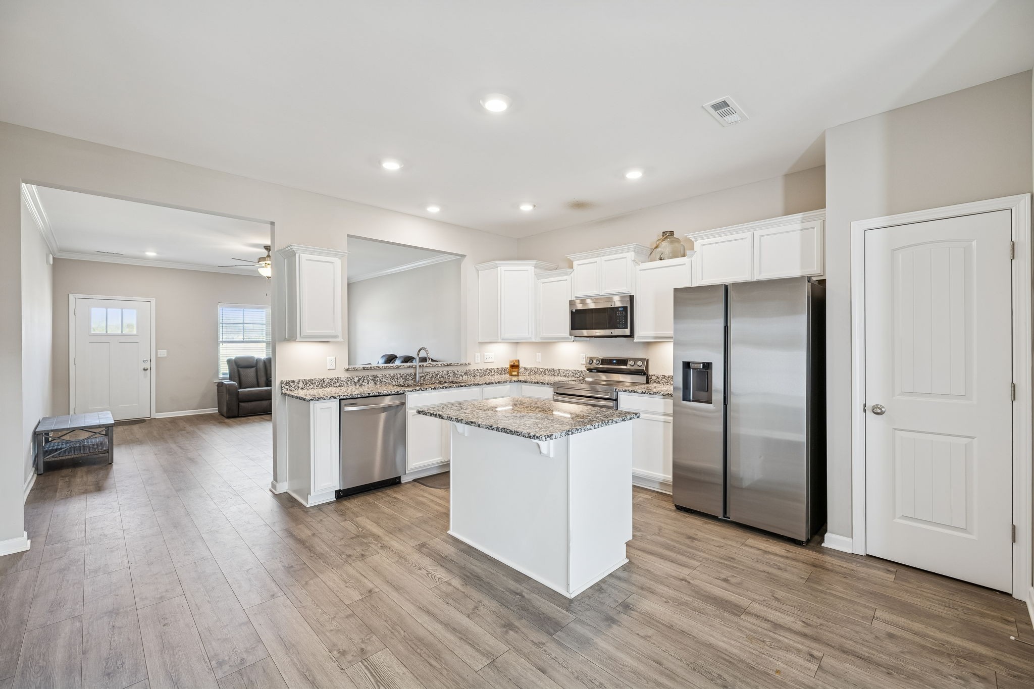 501 Ruby Cate Way Murfreesboro, TN 37128 - Photo 8 of 27 a kitchen with stainless steel appliances kitchen island wooden floors and white cabinets