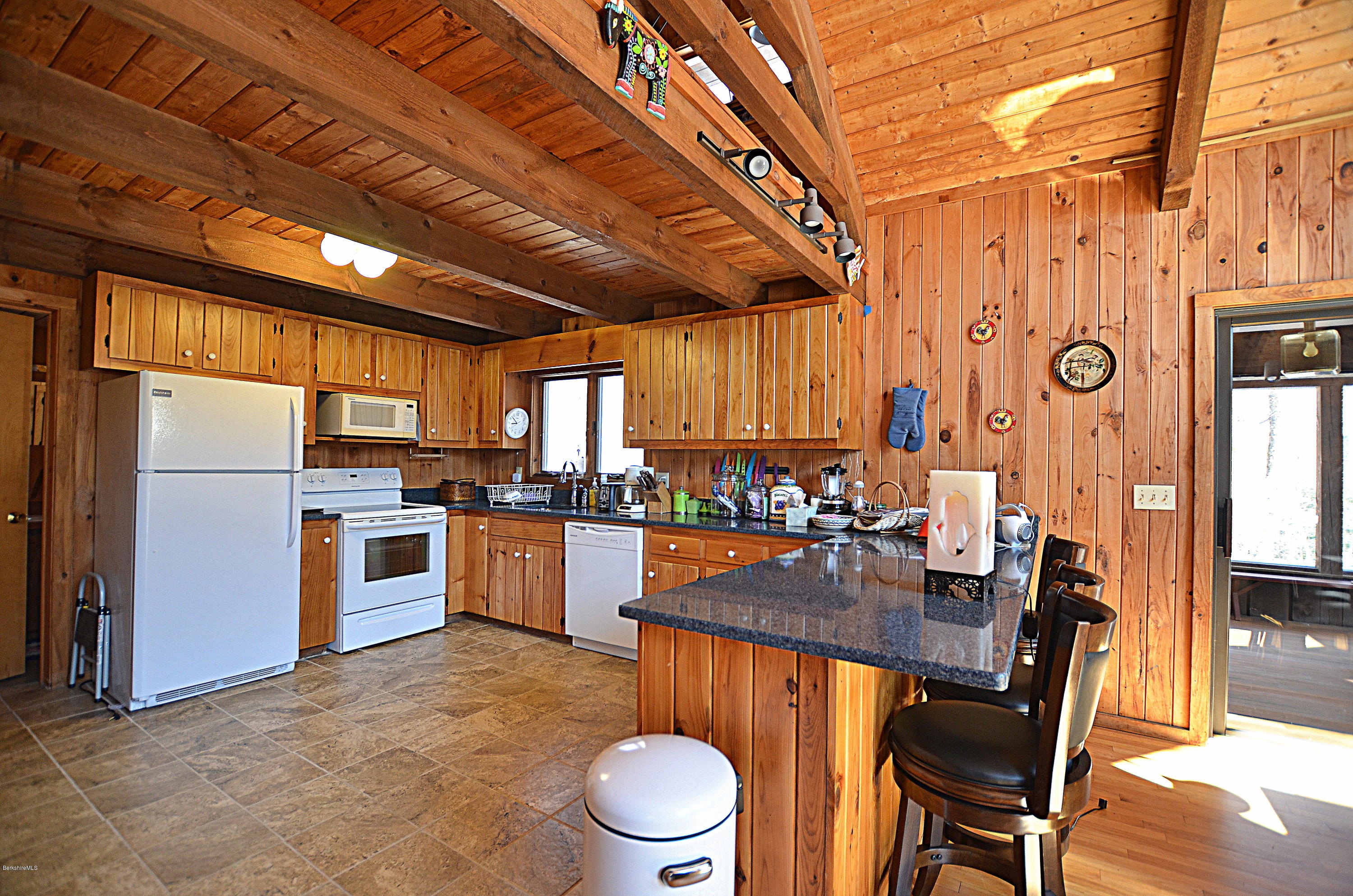 164 Moberg Road Becket, MA 01223 - Photo 3 of 25 a kitchen with a table chairs stove and refrigerator