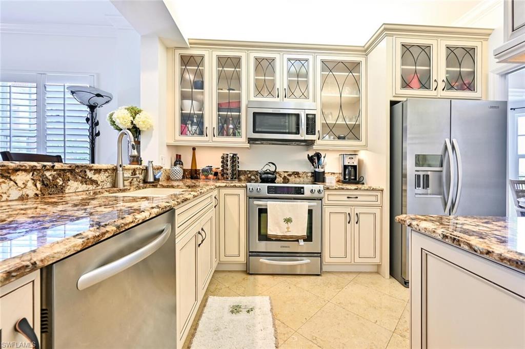 401 Bayfront Place, Unit 3301 Naples, FL 34102 - Photo 10 of 24 a kitchen with stainless steel appliances granite countertop a stove and a refrigerator
