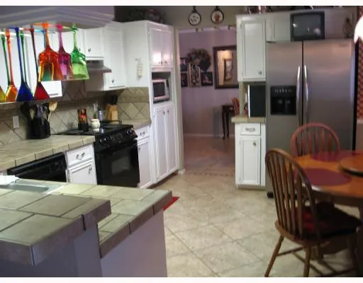 a kitchen with stainless steel appliances kitchen island granite countertop a refrigerator and a stove