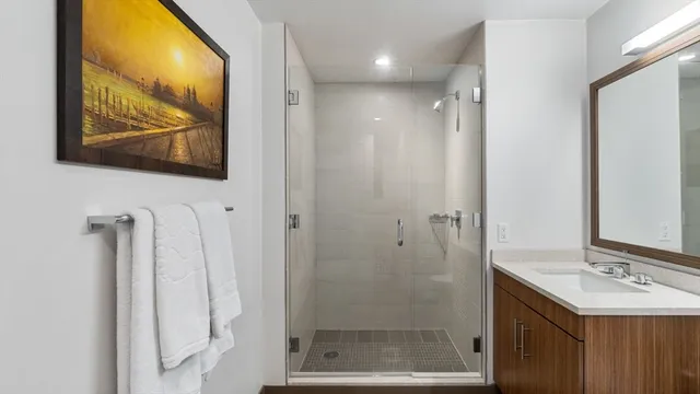 a bathroom with a sink mirror and a shower