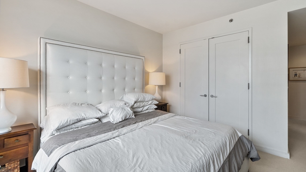 580 Washington Street, Unit 1105 Boston, MA 02111 - Photo 10 of 28 a bedroom with a bed and a mirror