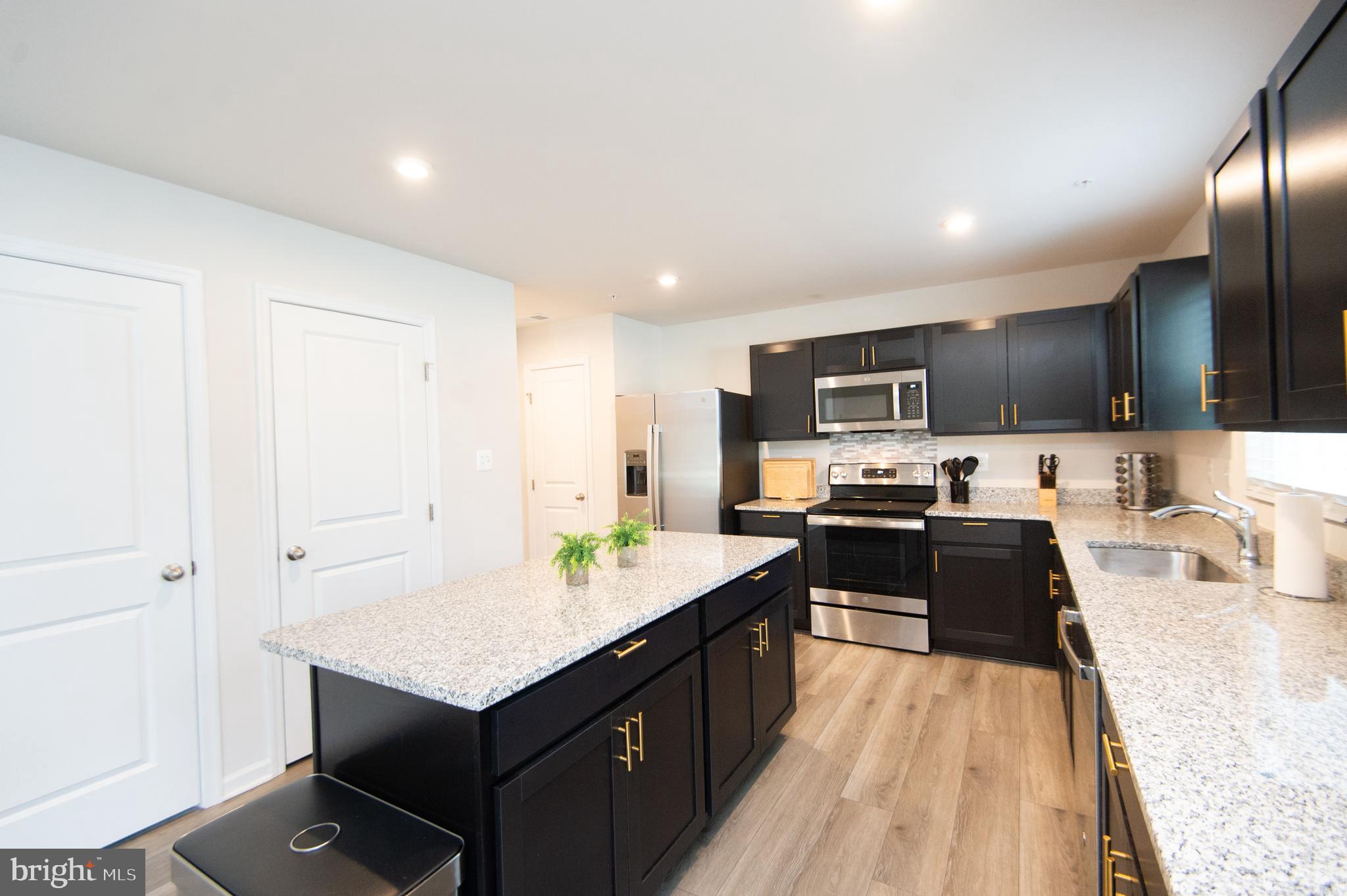 120 Mariners Way Cambridge, MD 21613 - Photo 8 of 44 a kitchen with granite countertop a sink counter top space appliances and cabinets