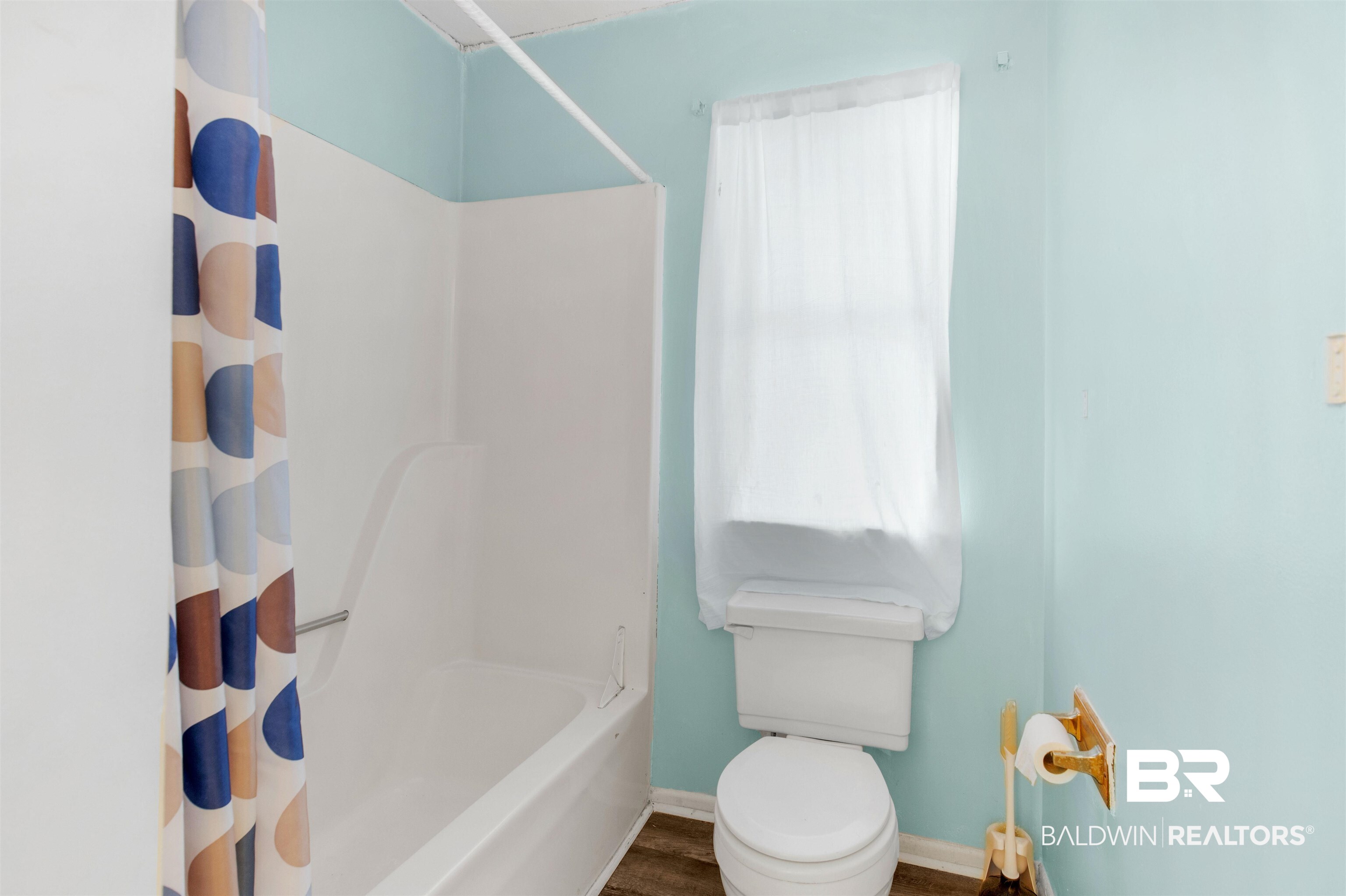 28290 Canal Road Orange Beach, AL 36561 - Photo 18 of 32 Bathroom with toilet, wood finished floors, shower / bath combo with shower curtain, and baseboards