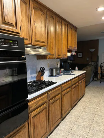a kitchen with stainless steel appliances granite countertop a sink stove and cabinets