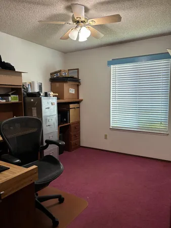 a view of workspace with furniture and a ceiling fan