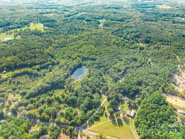 a aerial view of a houses with a lush green forest