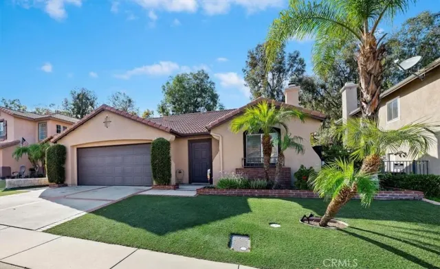 a front view of a house with a garden and trees