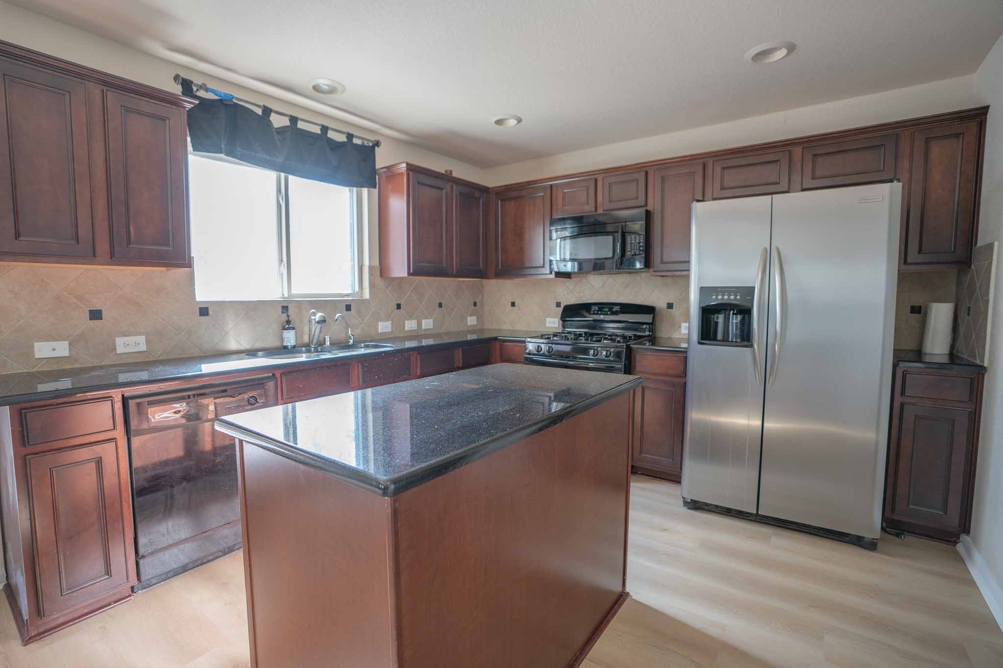6403 Lost Timber Lane Houston, TX 77066 - Photo 12 of 34 a kitchen with stainless steel appliances granite countertop a refrigerator a sink a stove a microwave and island