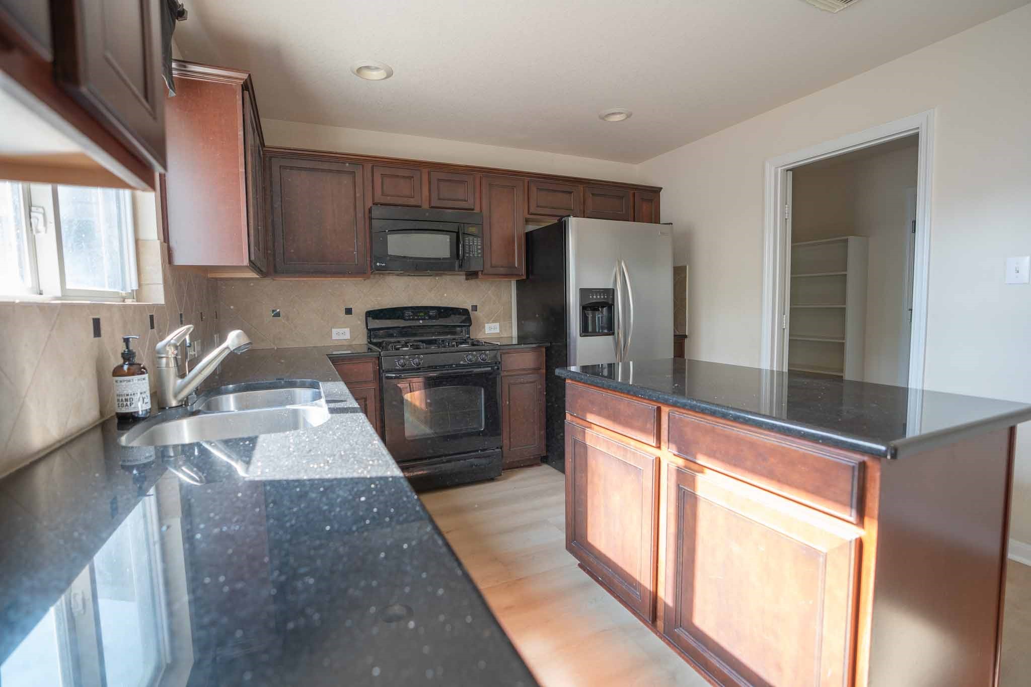 6403 Lost Timber Lane Houston, TX 77066 - Photo 13 of 34 a large kitchen with stainless steel appliances granite countertop a stove a sink and a refrigerator