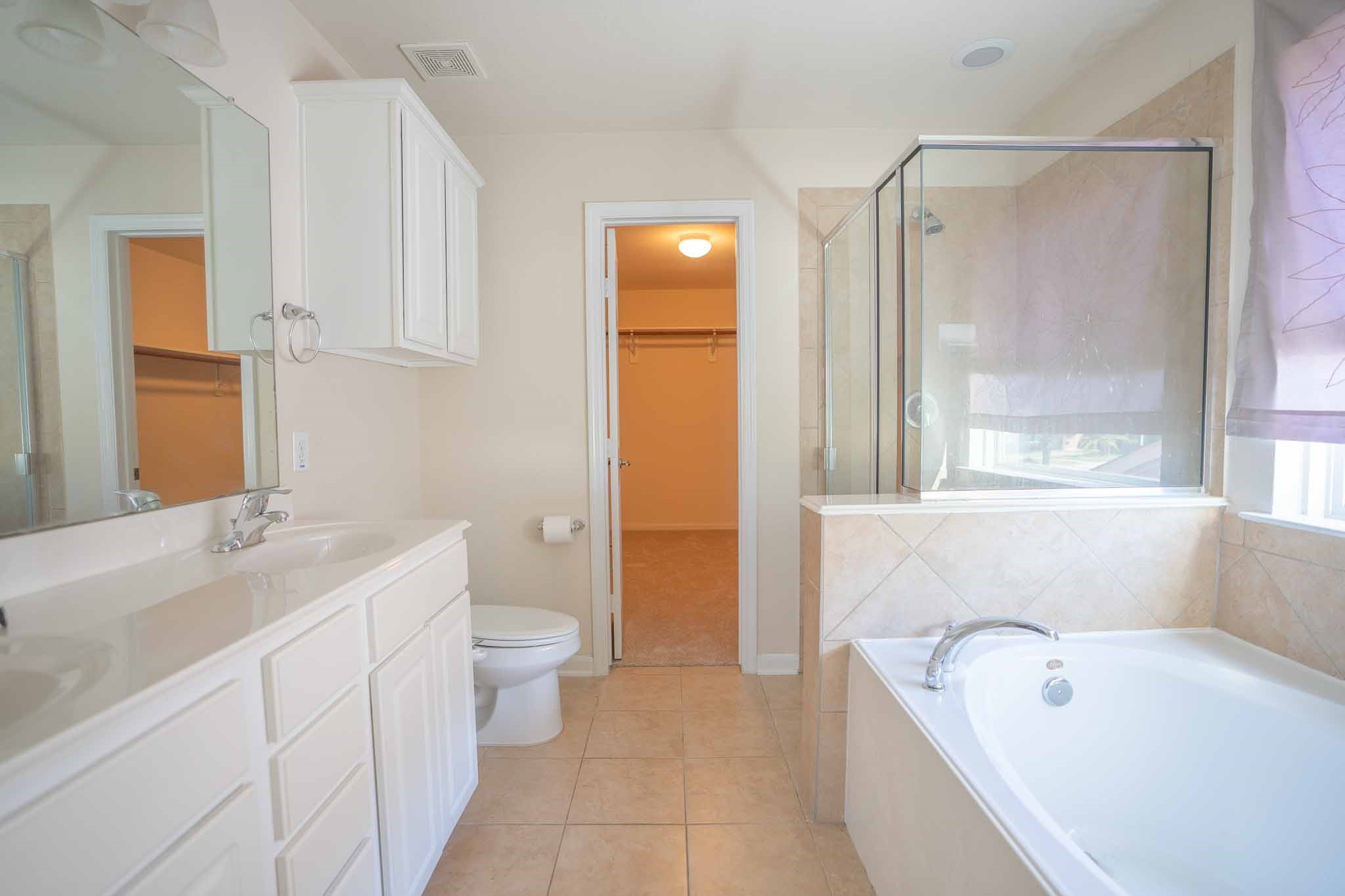 6403 Lost Timber Lane Houston, TX 77066 - Photo 21 of 34 a bathroom with a tub a sink and a large mirror
