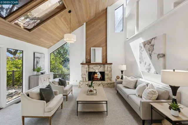 a living room with furniture fireplace and a large window