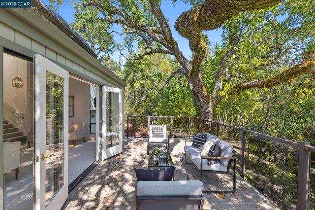 a view of a balcony with chairs and floor to ceiling window