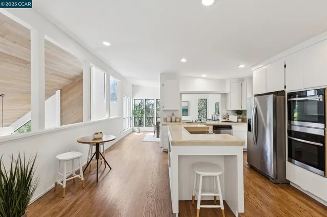 a kitchen with a dining table chairs refrigerator and cabinets