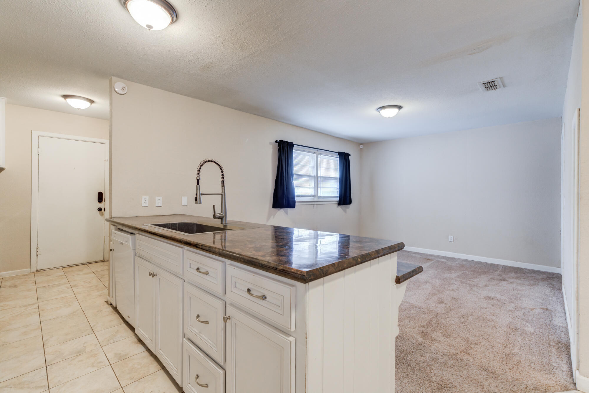 403 East 19th Street Littlefield, TX 79339 - Photo 22 of 34 a kitchen with granite countertop a sink and cabinets