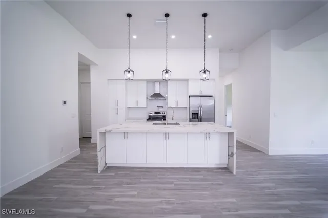 a kitchen with kitchen island a sink and a stove top oven