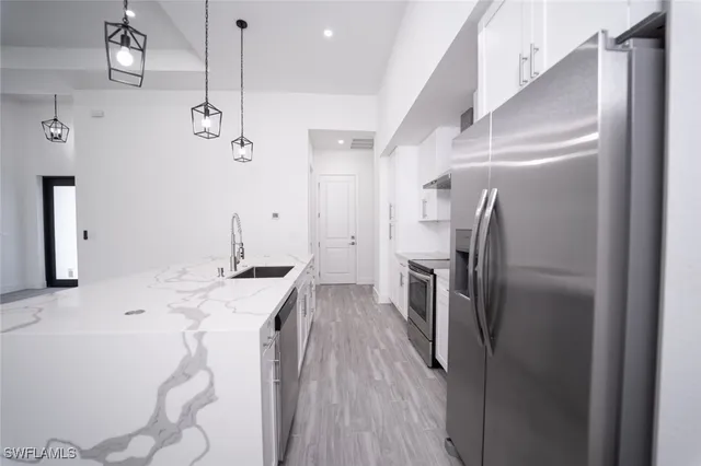 a view of an empty room with a fireplace and wooden floor