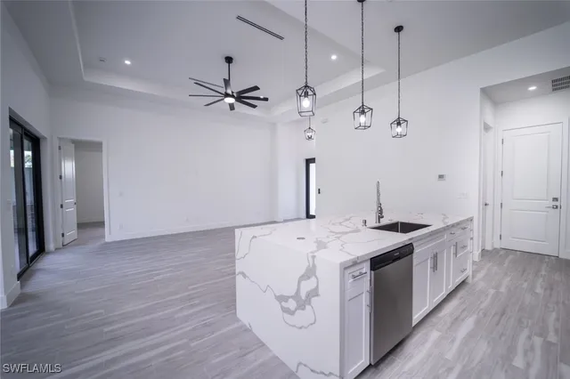 a kitchen with stainless steel appliances granite countertop white cabinets and a stove